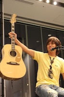 エルヴィス・プレスリーモデルのギターを掲げる上原子。