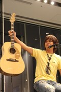 エルヴィス・プレスリーモデルのギターを掲げる上原子。