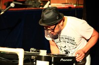 DJプレイを披露する坂詰克彦。老眼のためCDJのモニター表示がよく見えない。