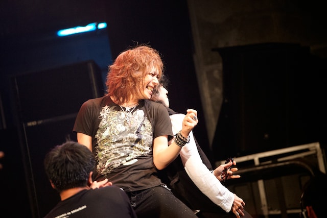 背中合わせでエアプレイをするヒーセとエマ。