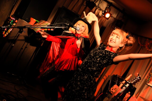ライブのオープニング、マント姿のあっこ（Dr / 左）と黒いワンピースのきさ（Vo, G / 右）。