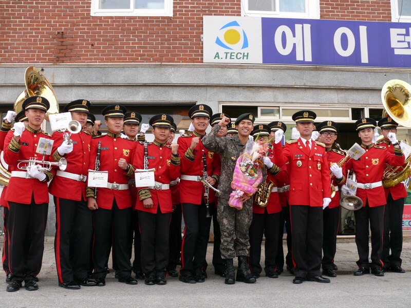 Kは軍の楽隊に見送られて施設を後にした。