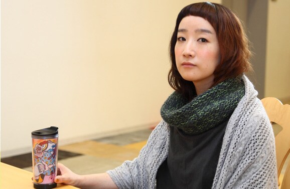 自身がデザインしたタンブラーを持つたむらぱん。