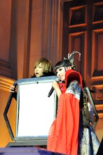 プリンセス天功（右）に箱に押し込められ、怯えた表情の鬼龍院翔（左）。