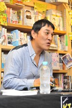 ファンと会話しながらサインを入れていくピエール瀧。