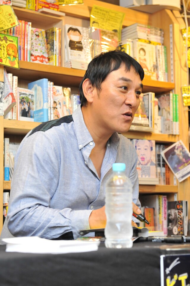 ファンと会話しながらサインを入れていくピエール瀧。