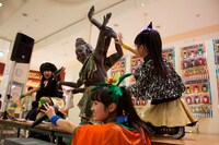 アシュラくんと記念撮影する坂本遥奈、咲良菜緒、伊藤千由李（写真左から）。