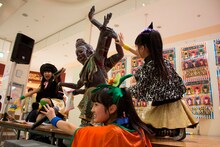 アシュラくんと記念撮影する坂本遥奈、咲良菜緒、伊藤千由李（写真左から）。