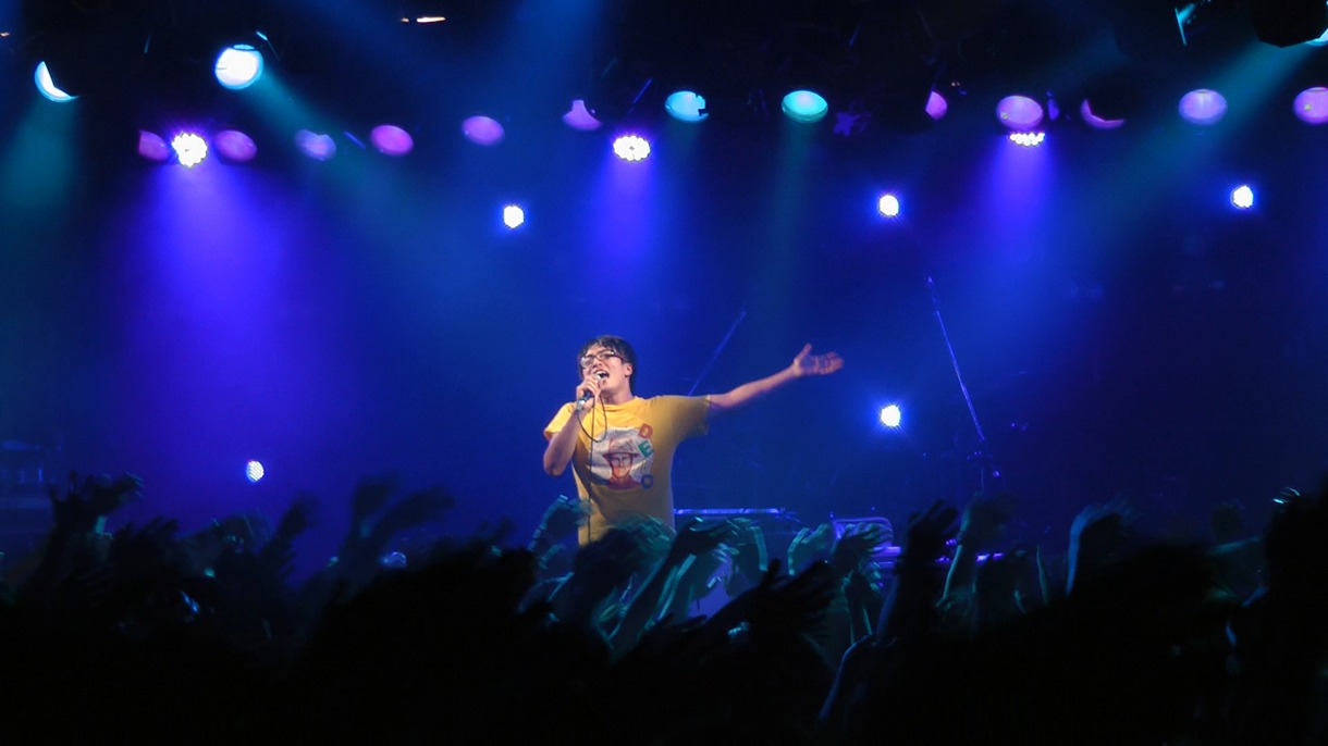 満員のオーディエンスを前に歌うハヤシ。