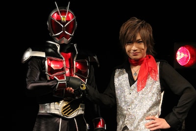 仮面ライダーウィザード（左）と固い握手を交わす鬼龍院翔（右）。