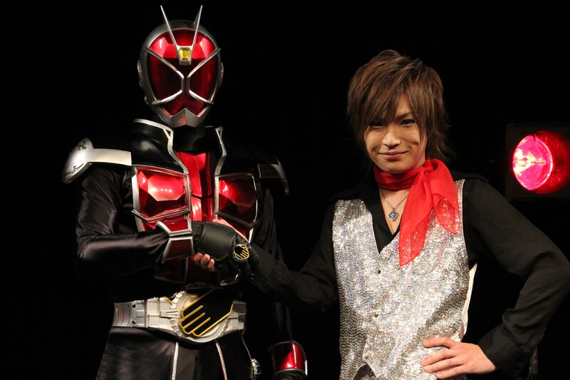 仮面ライダーウィザード（左）と固い握手を交わす鬼龍院翔（右）。