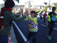 沿道の応援にハイタッチで応えるあいぽん。