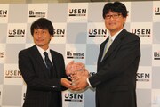 USENグループ会長・宇野康秀から記念の盾を受け取る、ソニー・ミュージックジャパンインターナショナル代表取締役・石橋正。