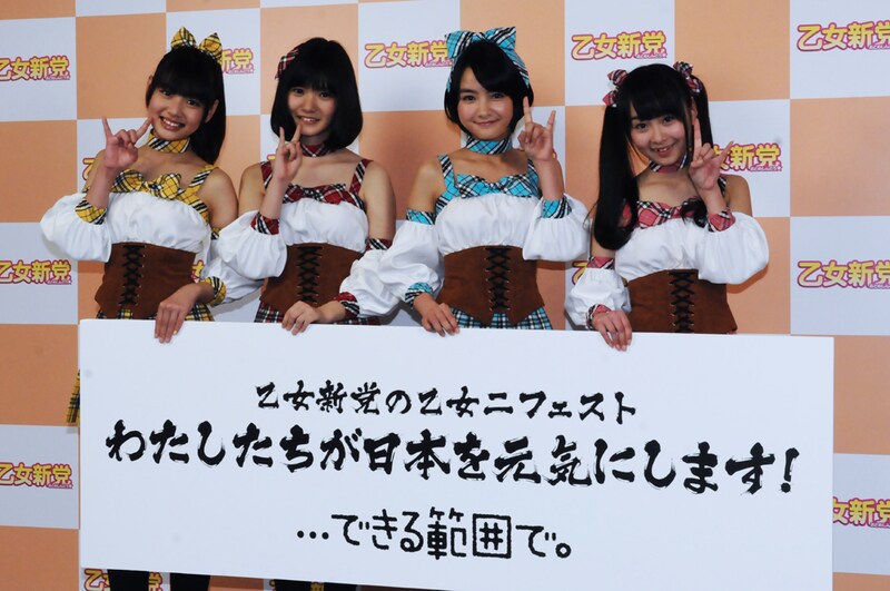 「乙女ニフェスト」が記されたボードを手にした乙女新党。