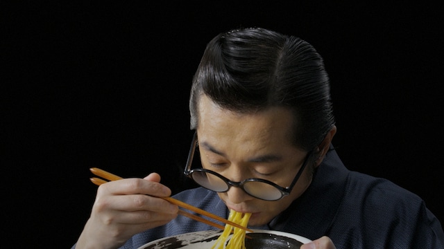 桃屋CM「辛そうで辛くない少し辛いラー油 ラー油は桃屋 塩ラーメン編」より。ラー油入りラーメンを一口すすって“のり平”化する増子直純。