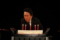 ファンが見守る中でロウソクを吹き消す布袋寅泰。