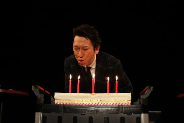 ファンが見守る中でロウソクを吹き消す布袋寅泰。