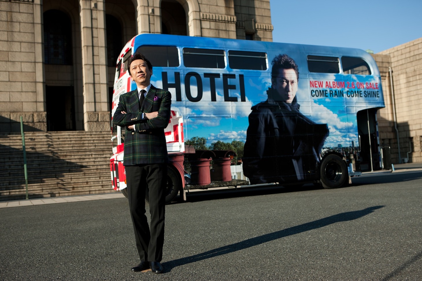 日中に特別仕様のロンドンバスの前でフォトセッションに応じた布袋寅泰。