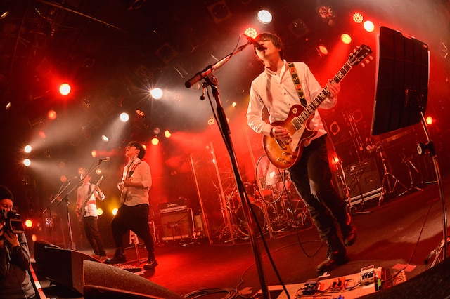 この日はゲストのCharm（写真左から2番目）を含めた4人とも、シンプルな白シャツ姿でステージに立った（撮影：古溪一道）。