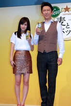 「麦とホップ」を手にほほえむ前田敦子と布袋寅泰。