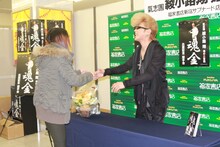 会場に駆けつけたファンと握手を交わす綾小路翔。