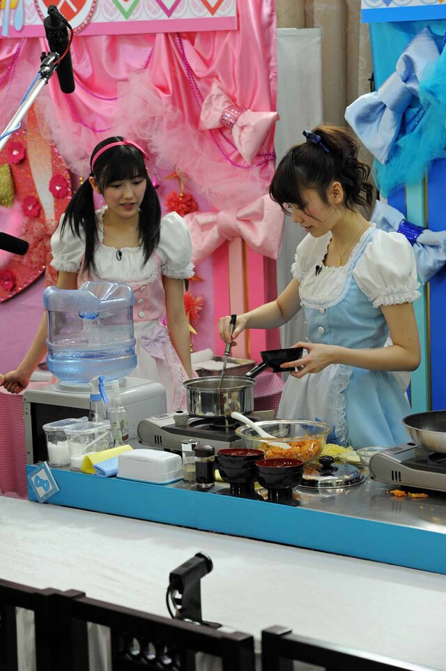 島崎遥香（右）の味噌汁作りを心配そうに見つめる渡辺麻友（左）。