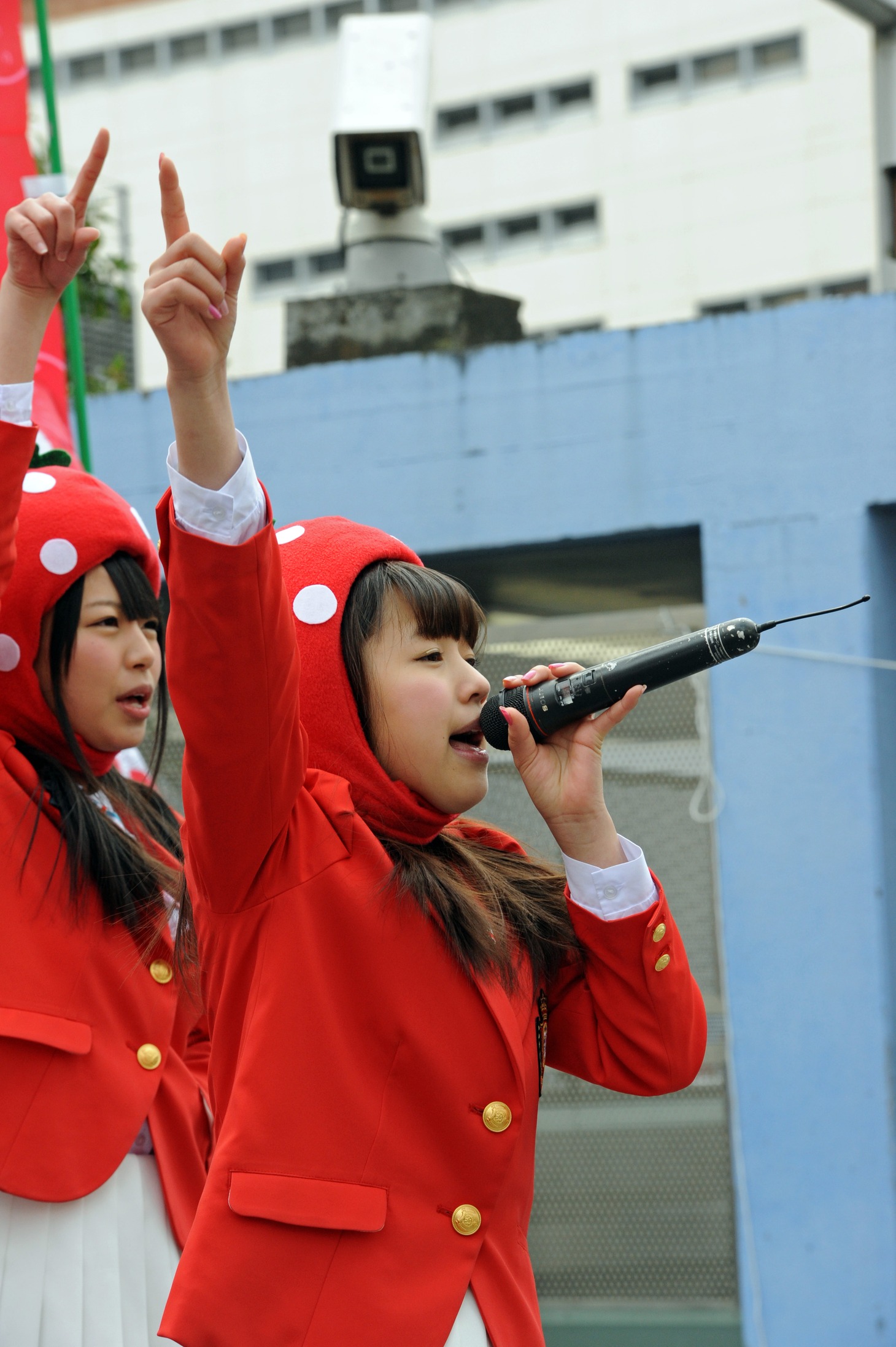 いちごの被り物を被って歌う高木悠未。