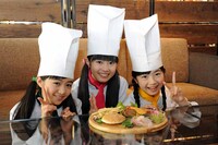 ハンバーガーの具材が盛られたプレートを前に微笑むミニパティ。