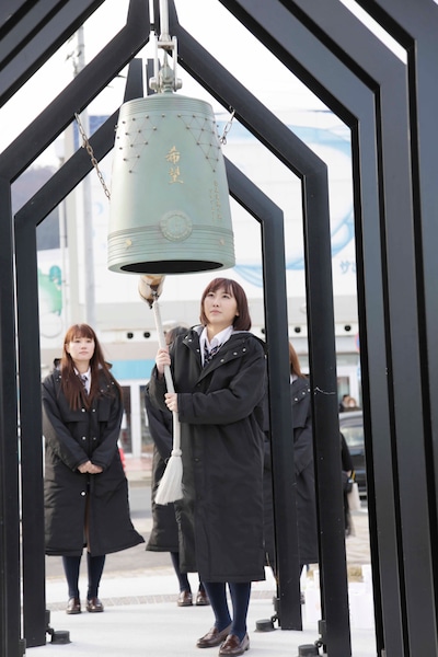 釜石駅前に設置された「復興の鐘」を鳴らす仁藤萌乃。(C)AKS