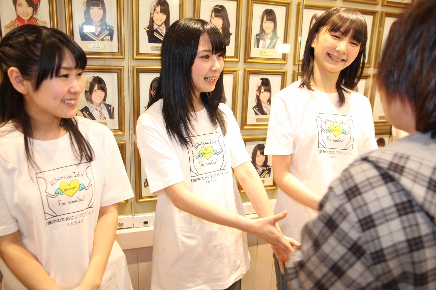 笑顔で握手する佐藤実絵子、高柳明音、秦佐和子（左から）。(C)AKS