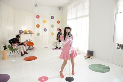 竹達彩奈「春がキミを綺麗にした」PVの1コマ。竹達彩奈（手前）、沖井礼二（左奥）、川本真琴（右奥）。