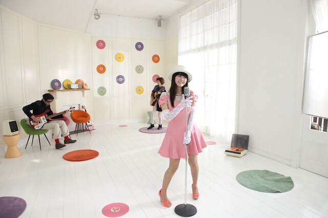 竹達彩奈「春がキミを綺麗にした」PVの1コマ。竹達彩奈（手前）、沖井礼二（左奥）、川本真琴（右奥）。