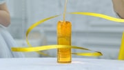 ボトルの形になった紅茶にリボンが巻き付いていく。