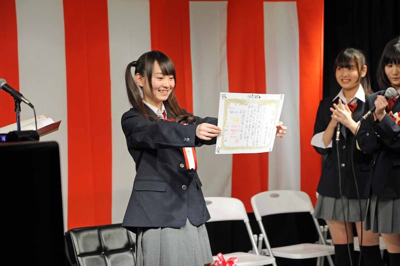 メンバー手書きの卒業証書をファンに見せる高橋優里花。
