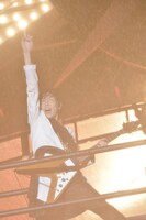 びしょ濡れになりながらギターを弾くShinji（G）。（撮影：江隈麗志）