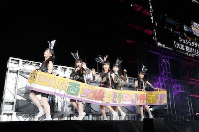 「宙飛ぶ！お座敷列車」でダンボール製の“西武線”に乗りステージを移動するももいろクローバーZ。（photo by Hajime Kamiiisaka）