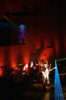 スクリーンに投影されたエネと共演するじん（自然の敵P）（撮影：Kobayashi TAXI）。