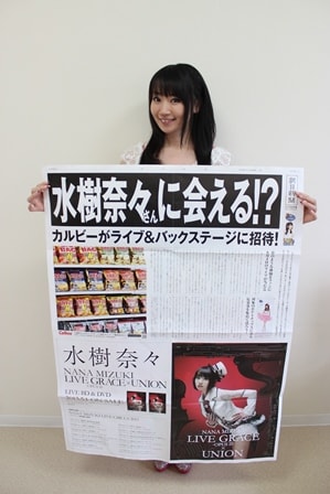 「水樹奈々 メガ新聞」の実物を手にする水樹奈々。