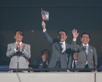 「EXILE LIVE TOUR 2013 “EXILE PRIDE”」のフラッグを掲げる安倍晋三首相（写真中央）。