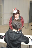 “ちびナノ”のコスプレをした海外ファンにサインをするナノ（手前）。