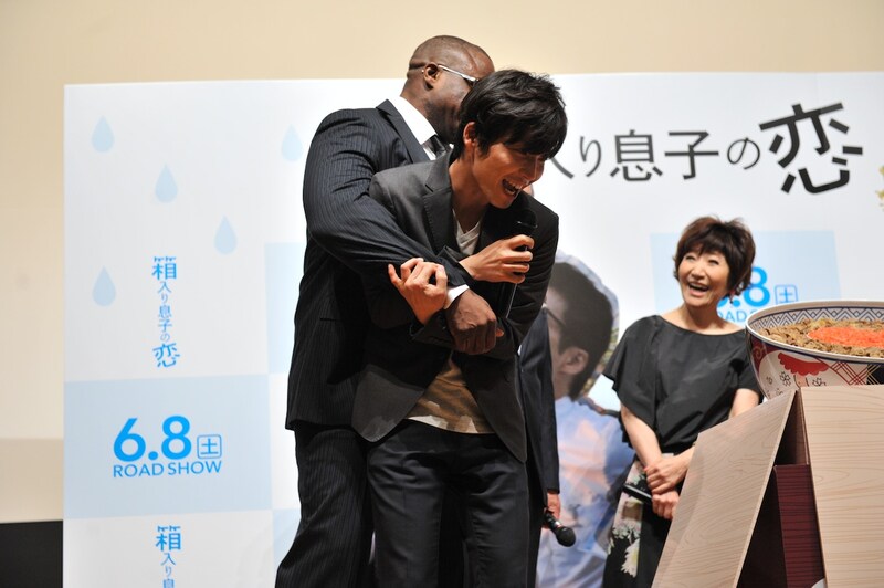 牛丼に近付こうとして羽交い締めにされる星野源。