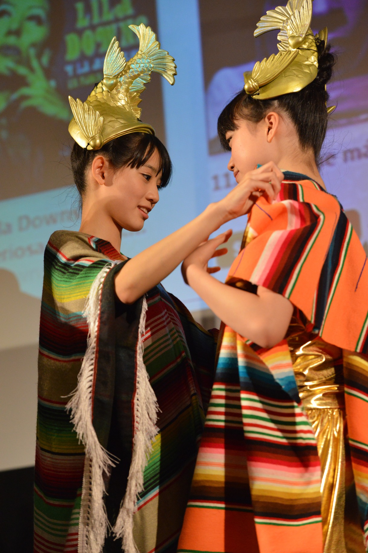 ポンチョを着せ合う秋本帆華（写真左）と伊藤千由李（右）。