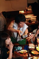 カッコいいポーズでお酌をする酒田耕慈（Dr）。