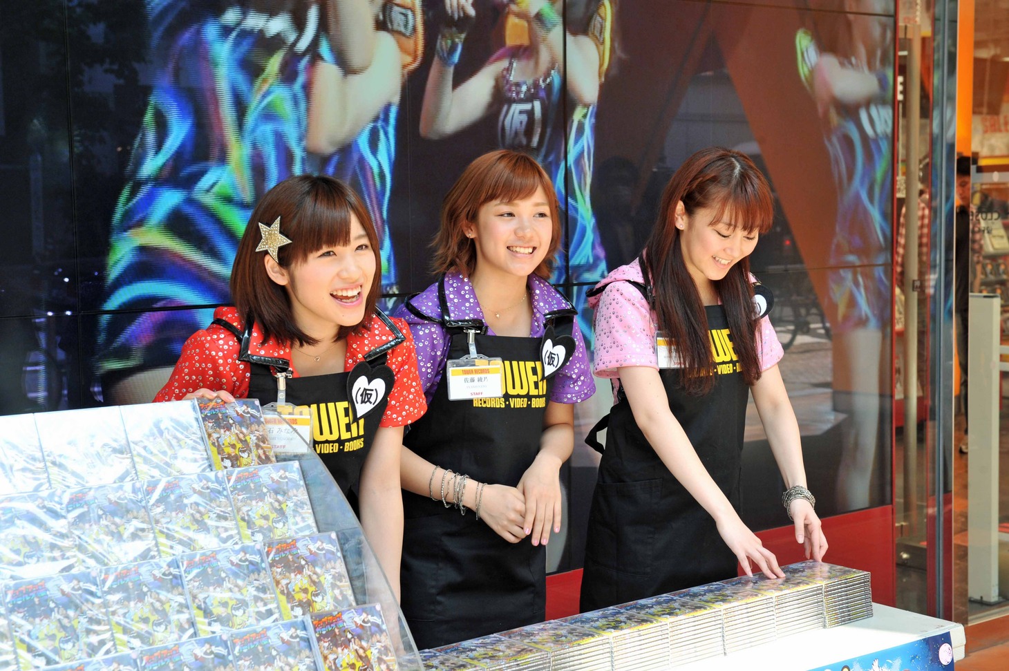 店頭から道行く人にCDをアピールする仙石みなみ、佐藤綾乃、古川小夏（左から）。