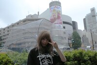 「なんだこれくしょん」のシリンダー広告が掲げられているラフォーレ原宿を背にしたきゃりーぱみゅぱみゅ。