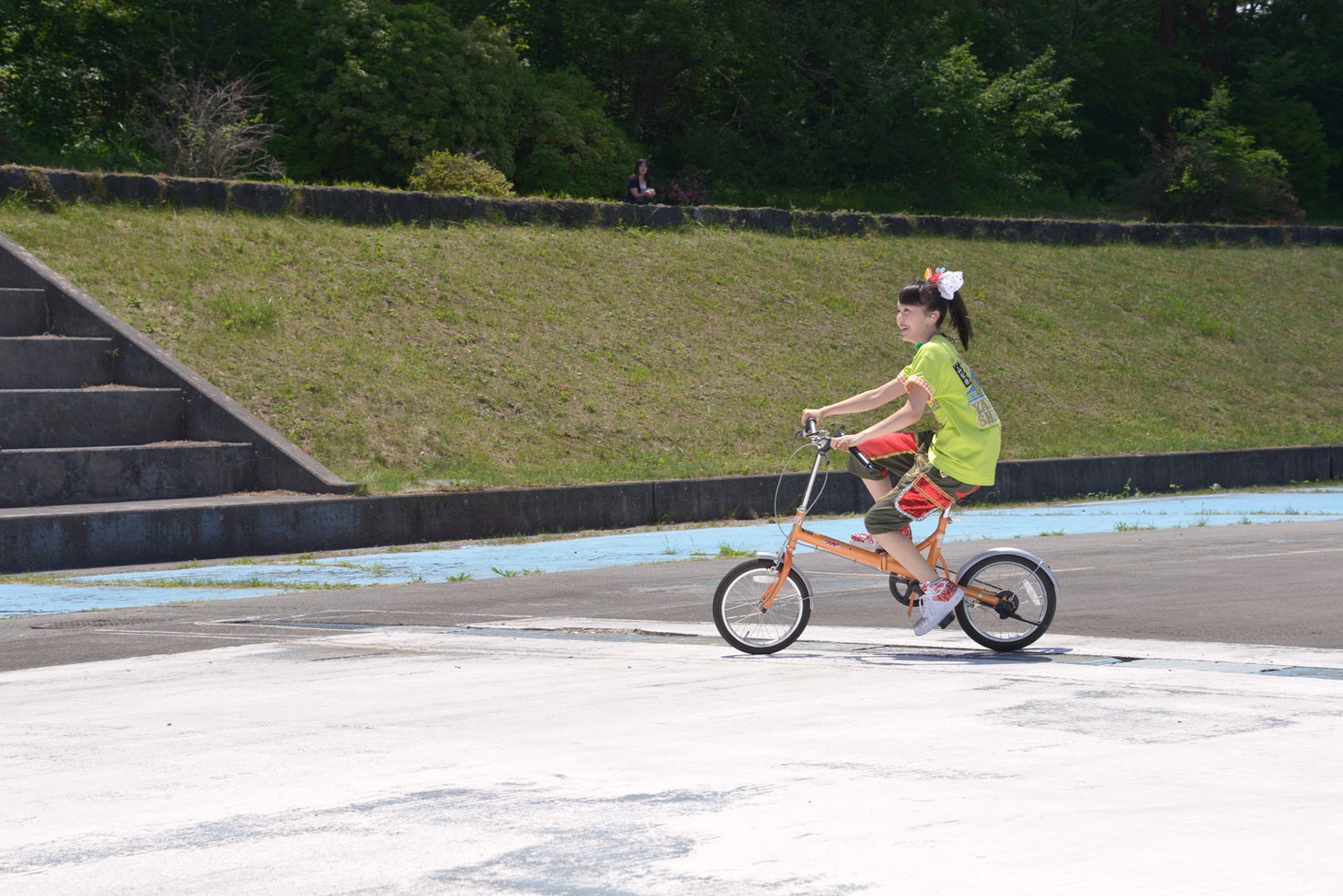 自転車で会場内を走る百田夏菜子。