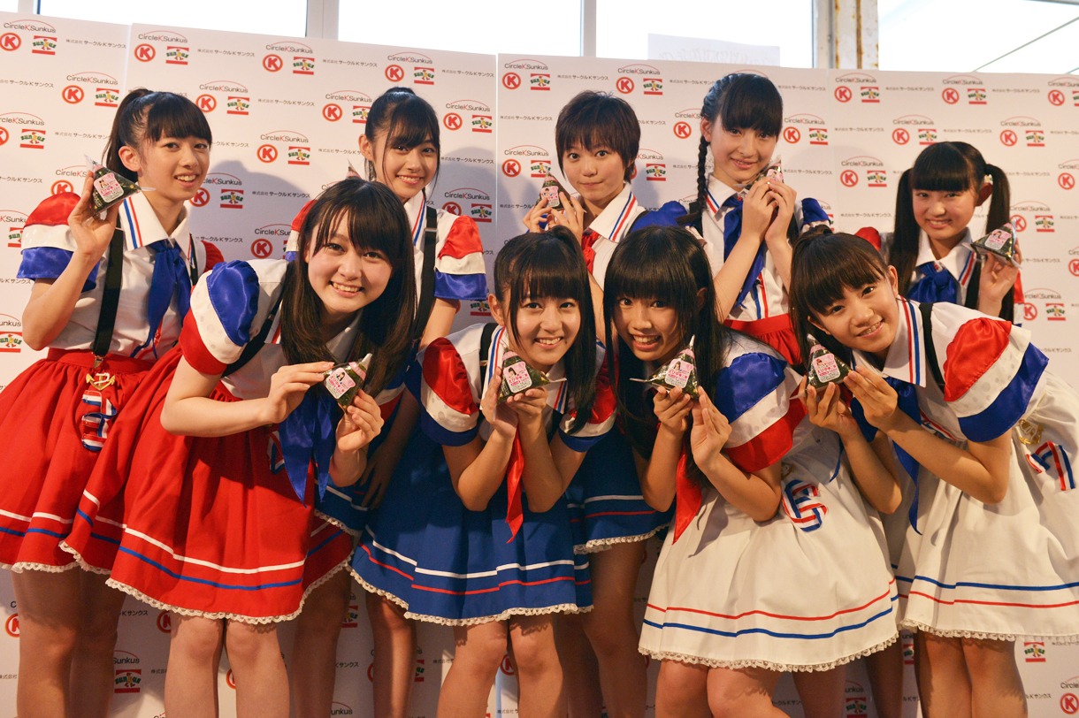 サークルKサンクスとのコラボ商品「えび塩風味海苔 えび中華ご飯」を手にマスコミ取材を受けたエビ中。初披露となった新衣装はサークルKサンクスのユニフォームを意識したものだ。