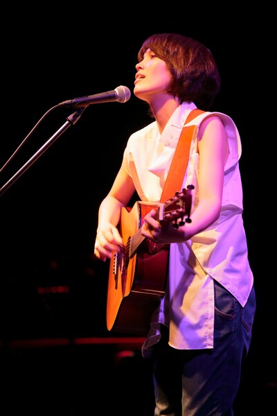アコースティックギターを抱え熱唱する井手綾香。