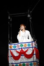 “まりぱんだ”の気球に乗って「帰郷」を歌う篠田麻里子。(c)AKS