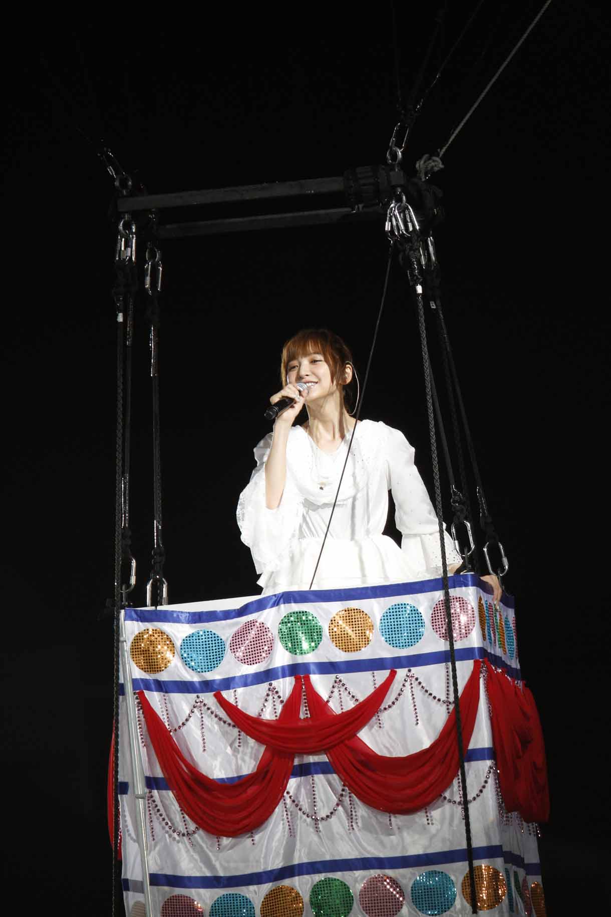 “まりぱんだ”の気球に乗って「帰郷」を歌う篠田麻里子。(c)AKS